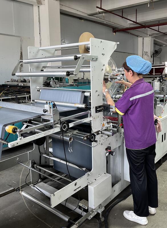 Employees debug plastic packaging bag production machines Employees debug plastic packaging bag production machines